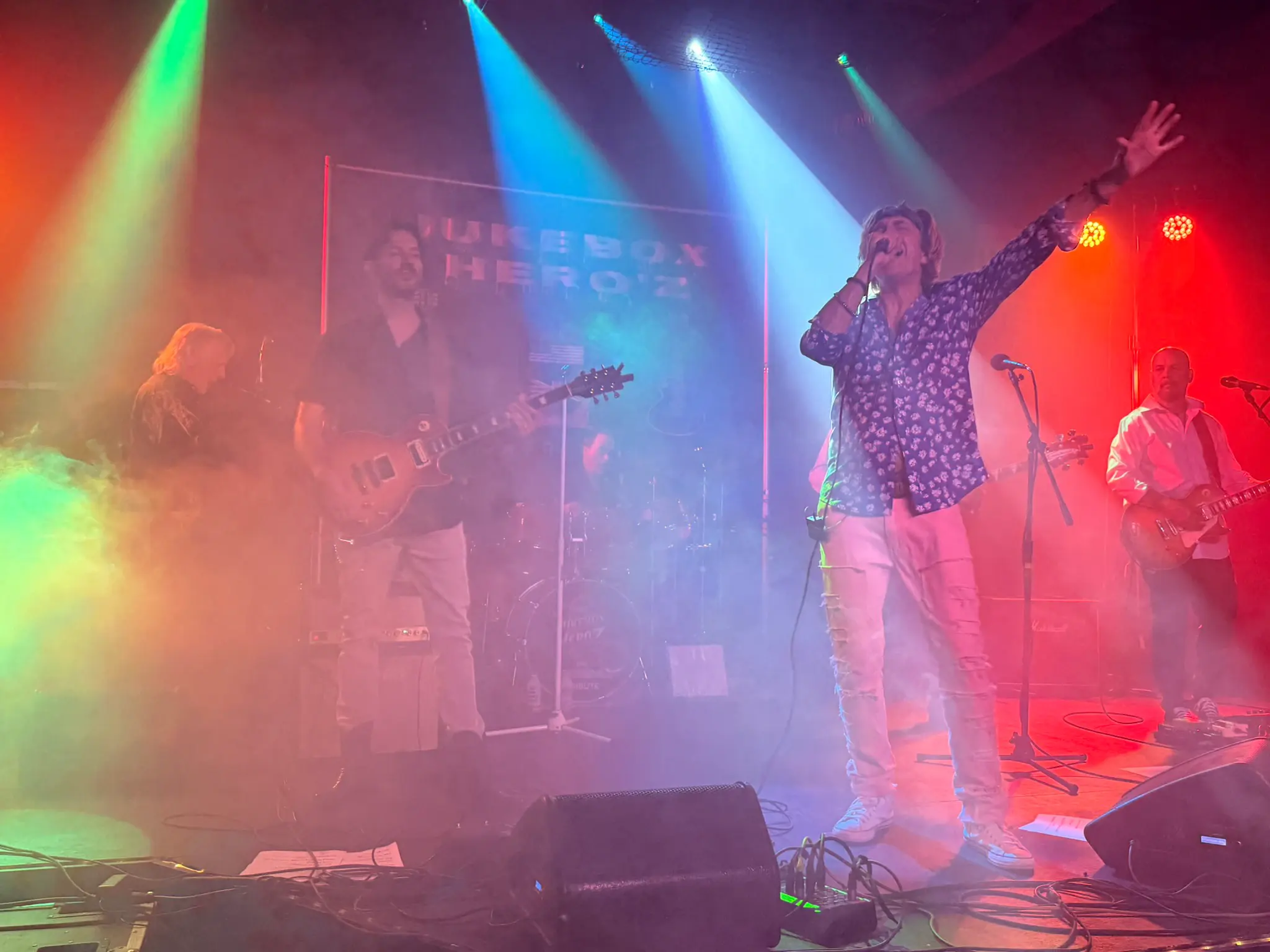 Jukebox Hero'z performing live under coloured stage lights